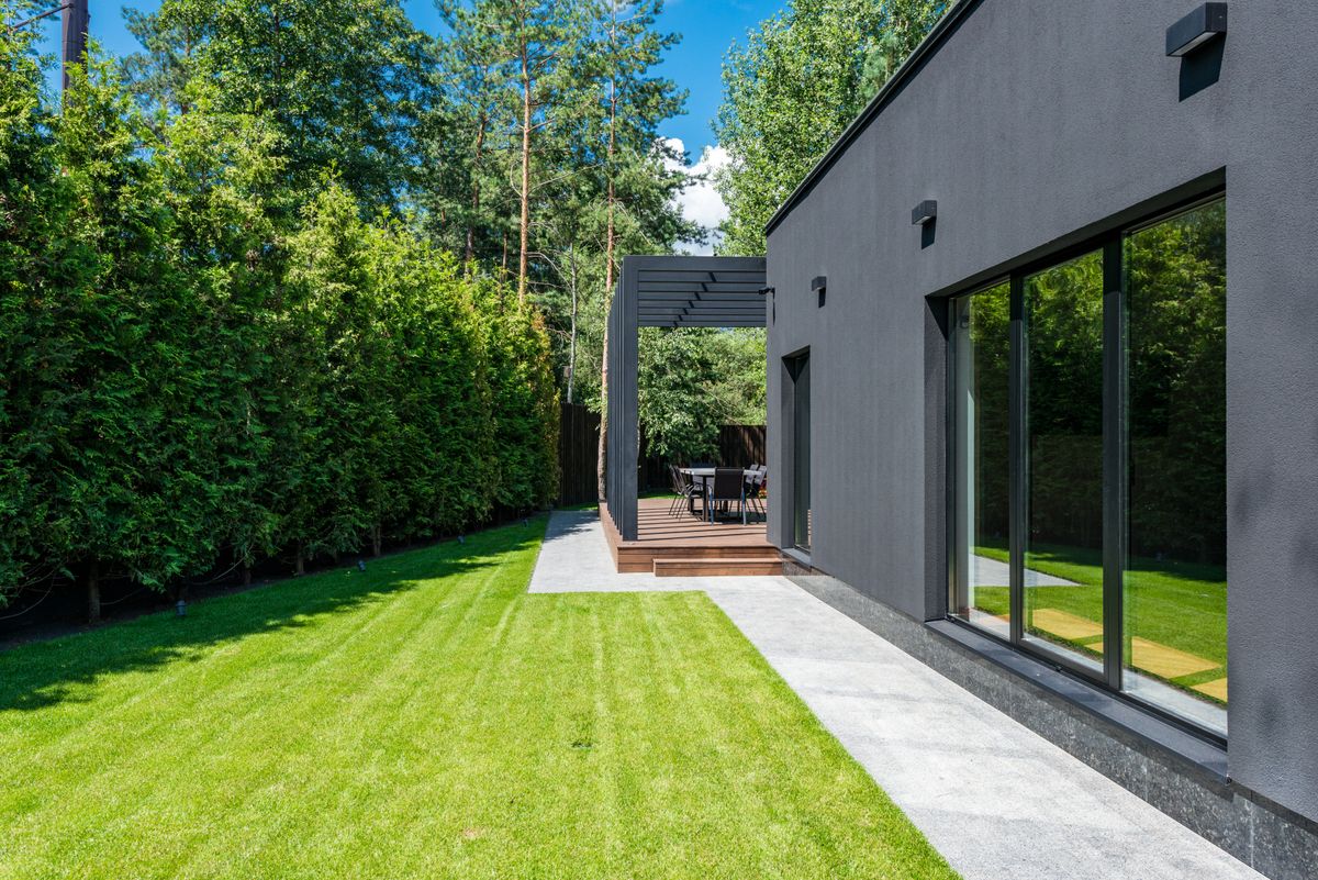 Modern dark-clad building with full-height glass doors
